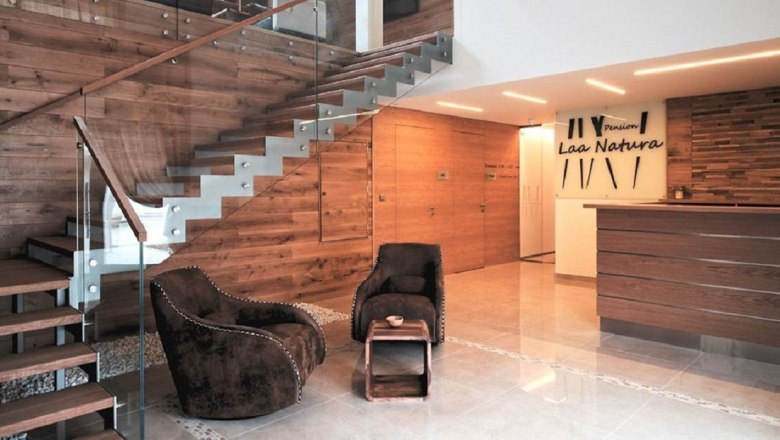 Modern entrance area with wooden paneling, staircase and reception.