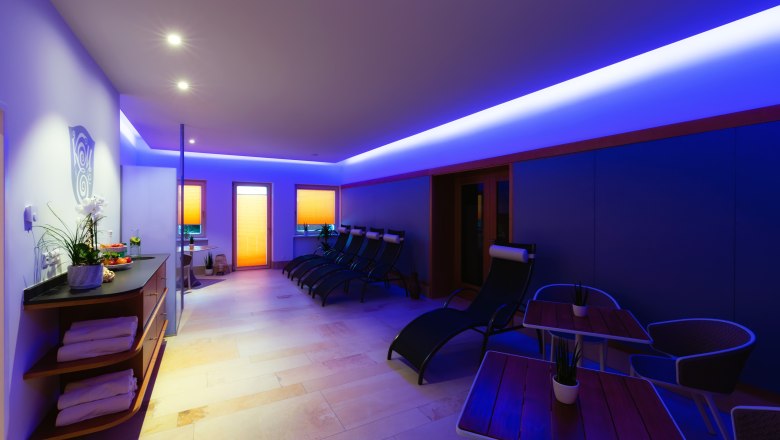 A modern wellness area with loungers, tables and blue lighting.