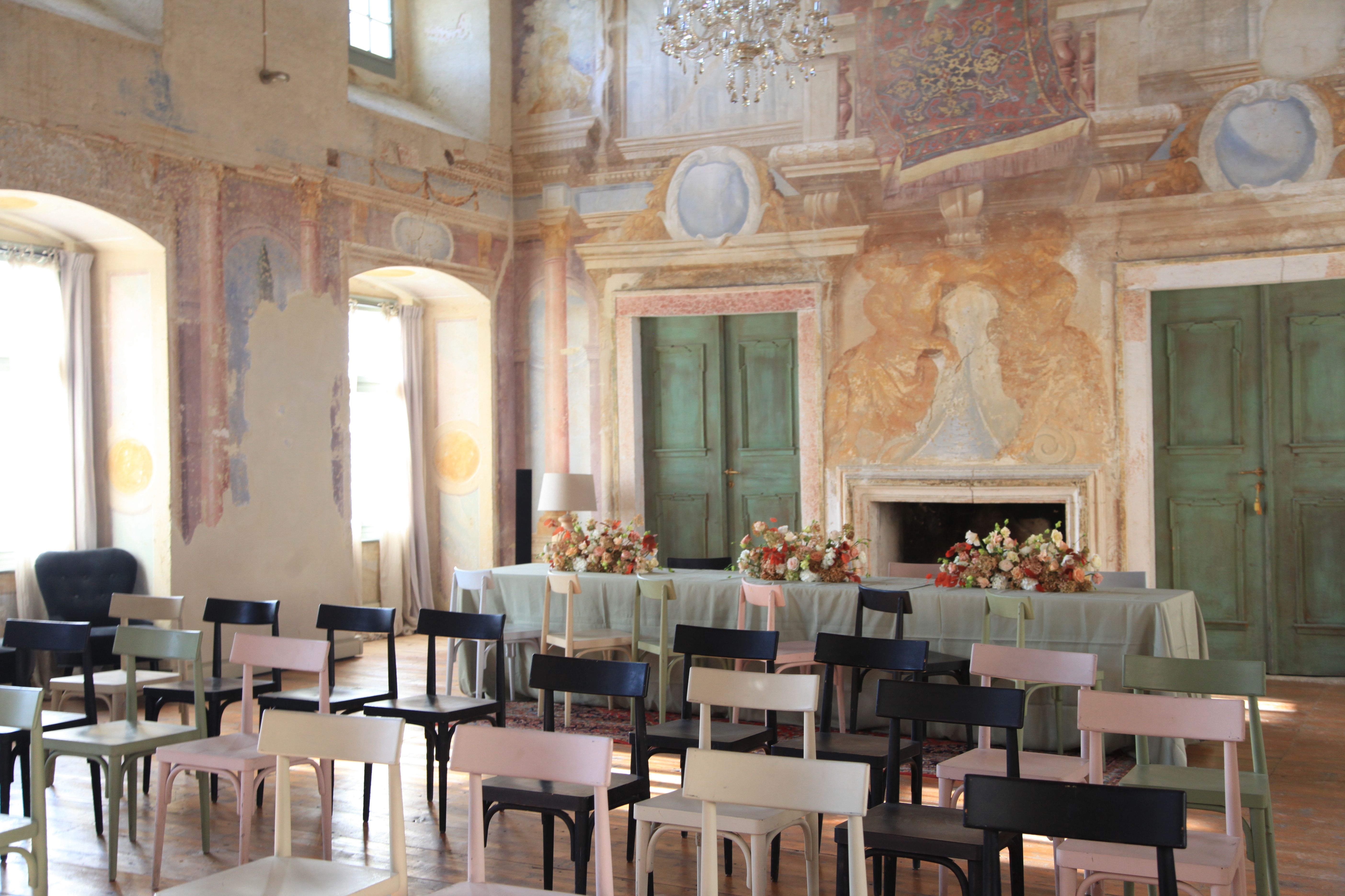 A festively decorated hall with painted walls, chairs and a table with flowers.
