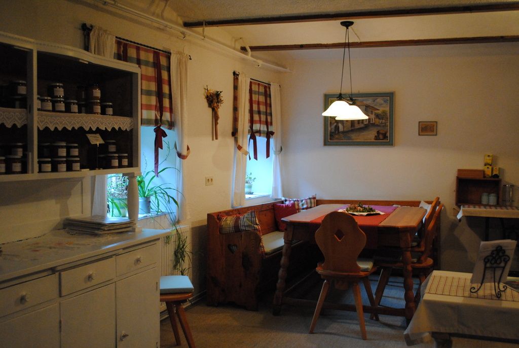 Cozy kitchen with wooden furniture and checkered curtains.
