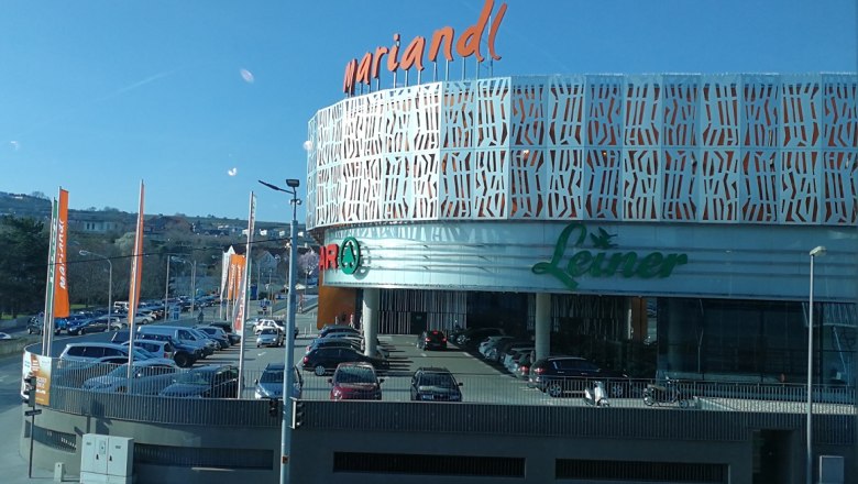 Mariandl shopping center in Krems with Leiner logo and parking spaces in front of it.