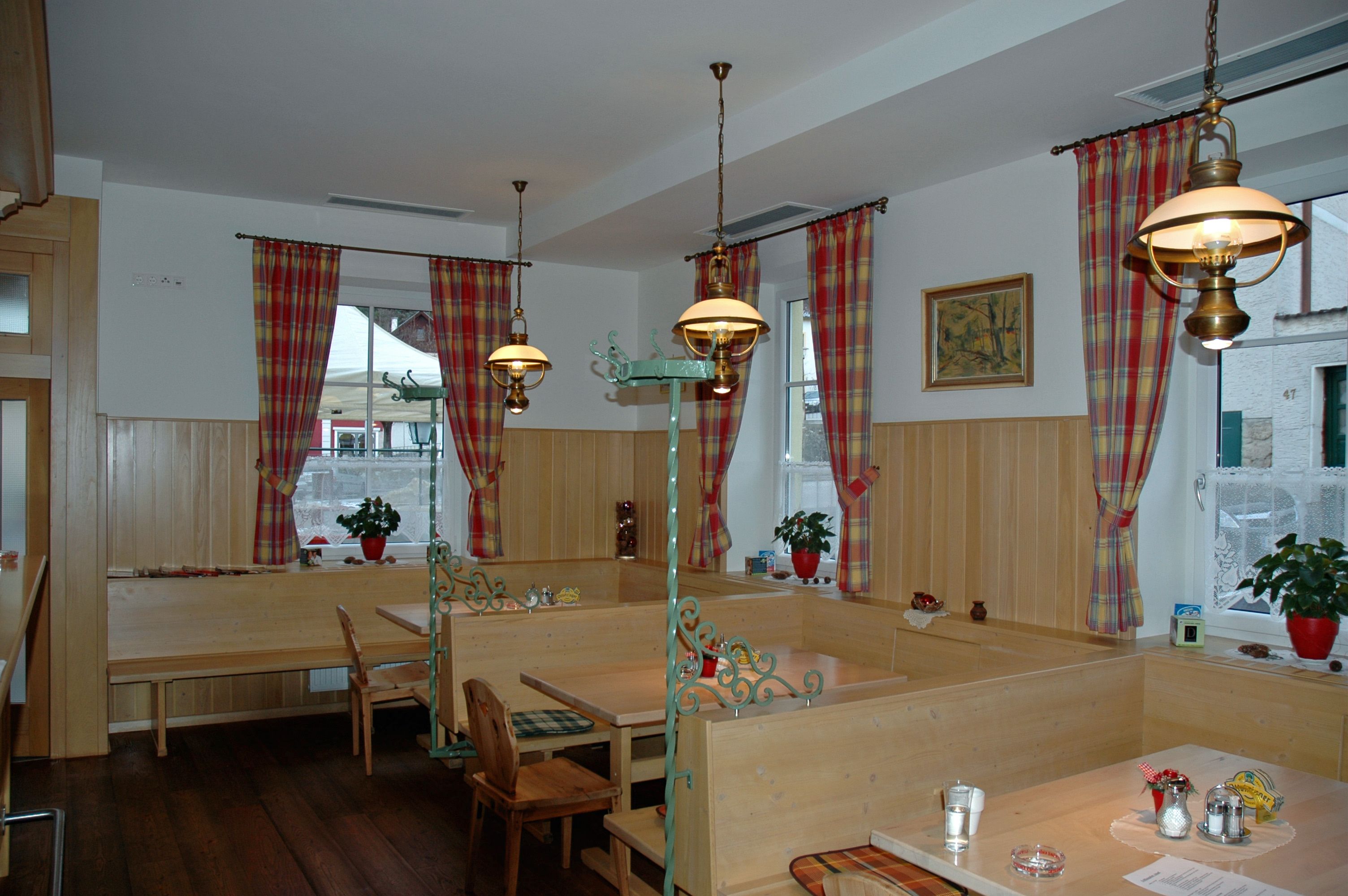 Cozy dining room with wooden furniture and checkered curtains.