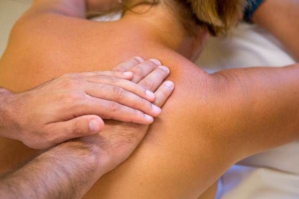 Close-up of a massage with hands massaging a person's back.