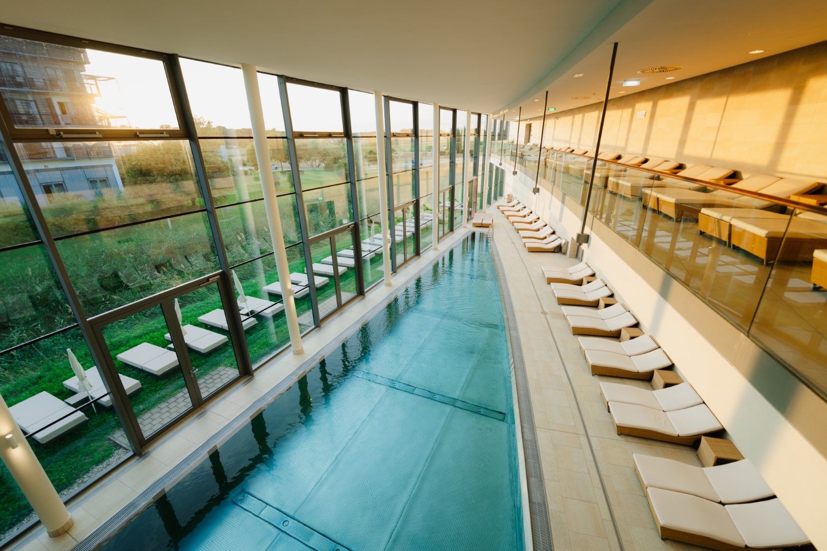 Interior view of a modern thermal spa with pool and sun loungers.