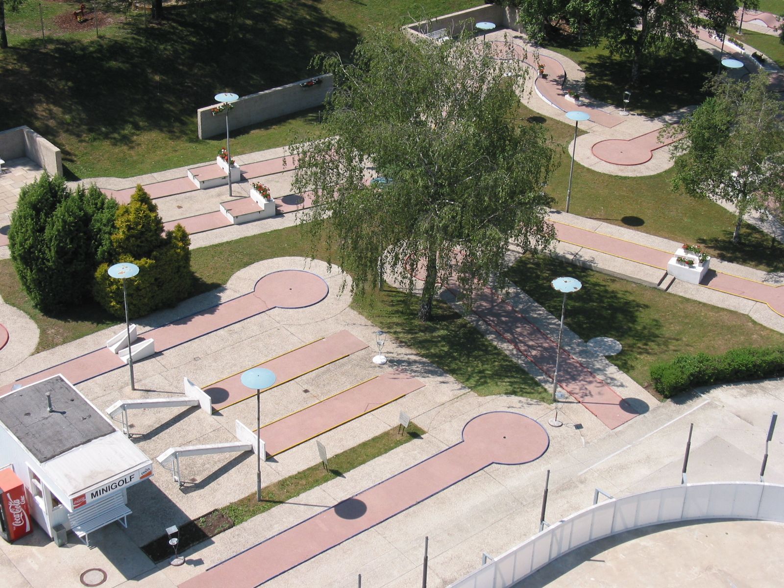 Aerial view of a miniature golf course with several courses and trees.