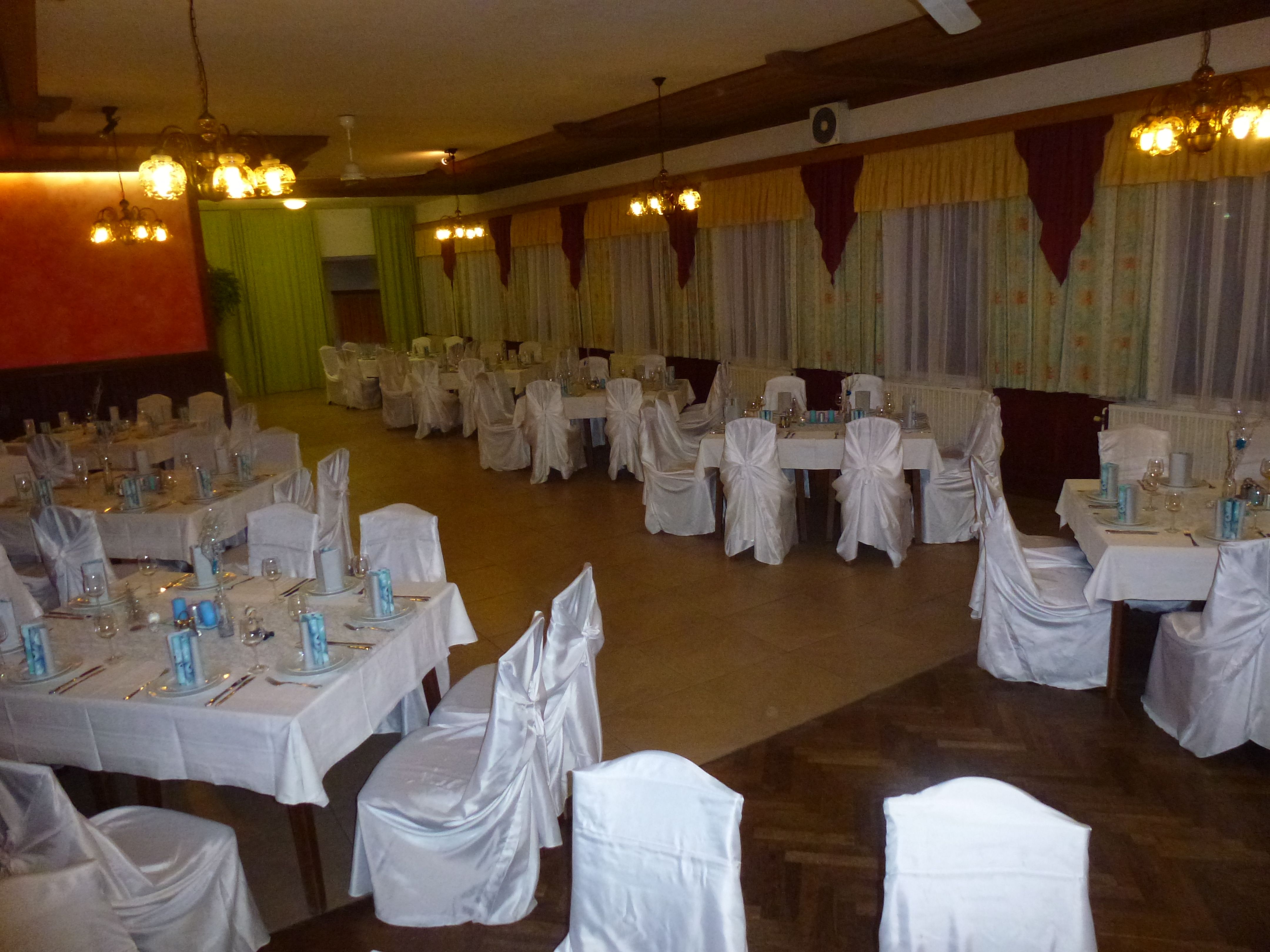 Elegant dining room with laid tables and white chair covers.