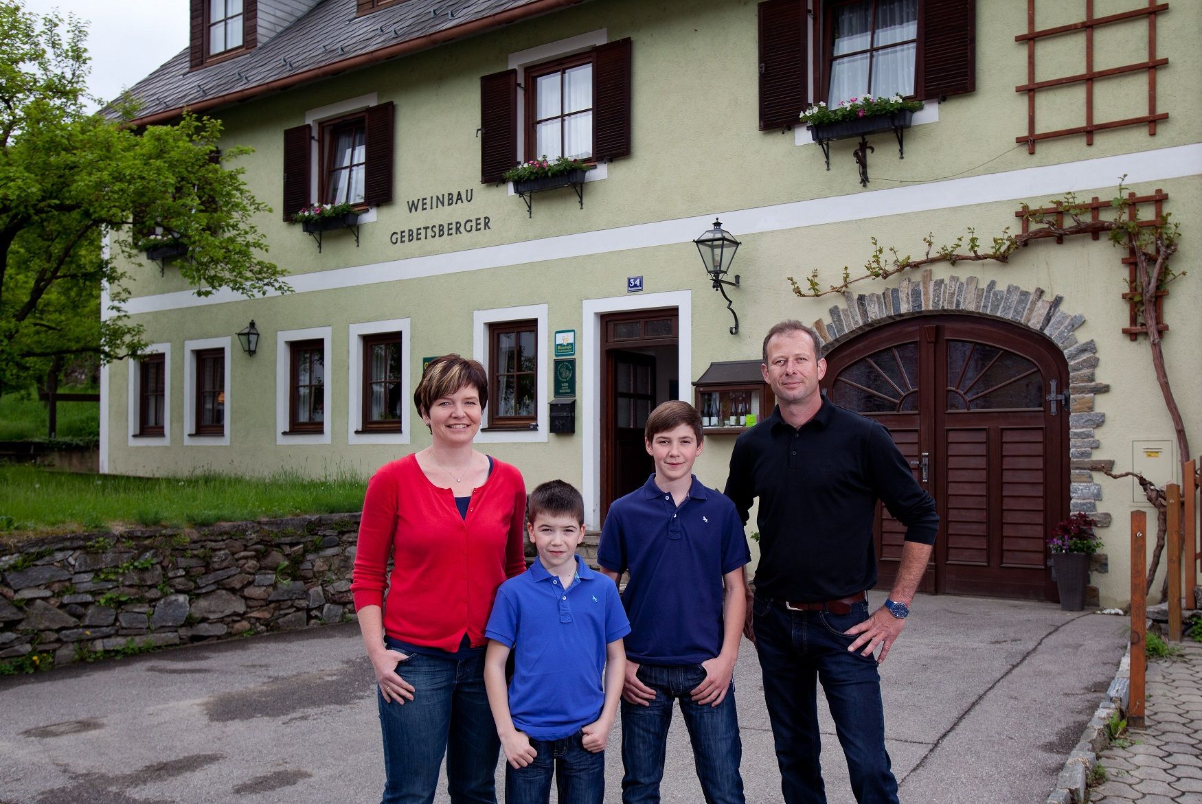 A family stands in front of a building labeled 'Weinbau Gebetsberger'.