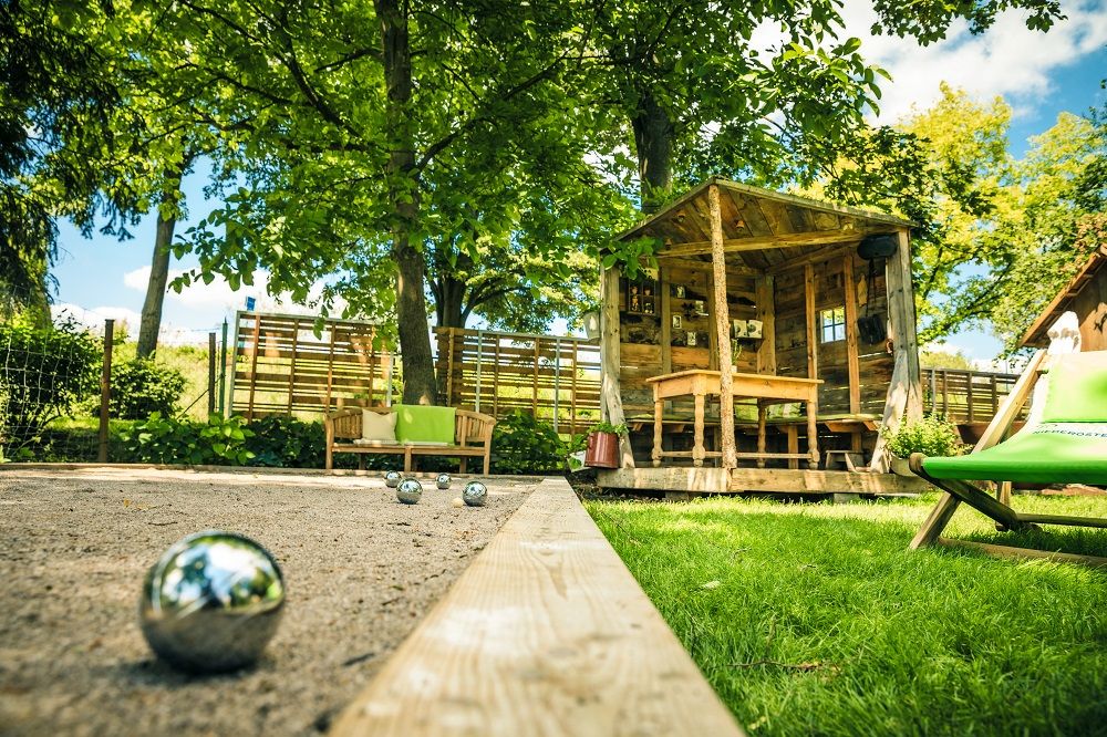 Garden with pergola and sand area with boccia ball, sun lounger next to it