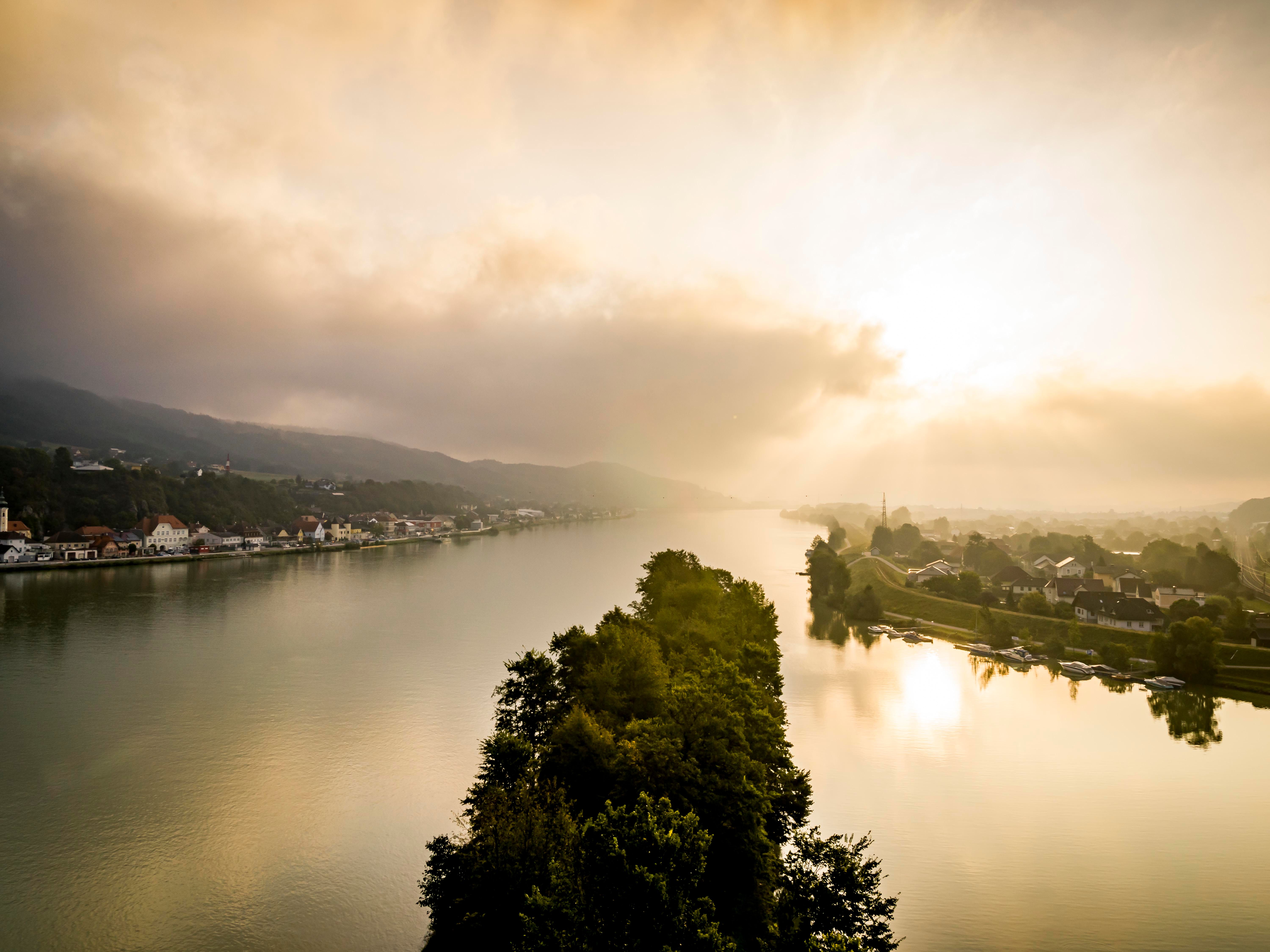 Aerial view of Krummnußbaum and Marbach at sunrise with river and cloudy sky.