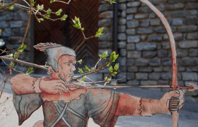Cardboard figure of Robin Hood with bow and arrow in front of a stone wall.