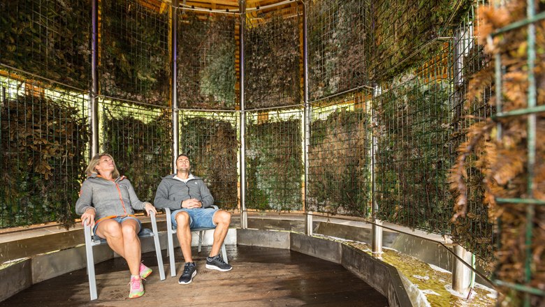 Two people sit relaxed in a graduation tower.
