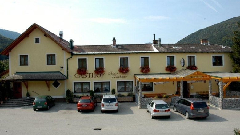 Gasthof Moser-Stockreiter with parked cars in front of it.