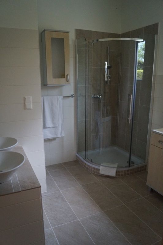 Modern bathroom with shower, washbasin and towel rail.