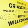 A sign with the word Welcome in various languages.