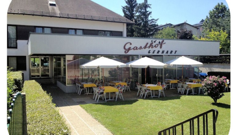 Exterior view of Gasthof Gerhart with terrace and parasols.