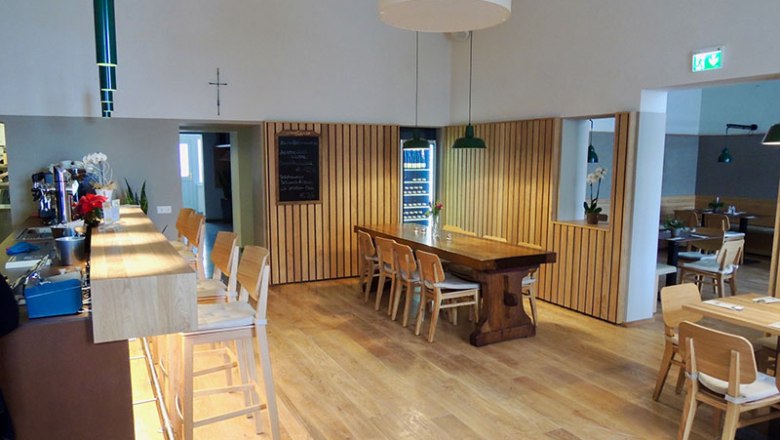 Interior view of a modern pub with wooden furniture and bar.