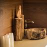 Rustic wooden washbasin with tap and wooden decor.