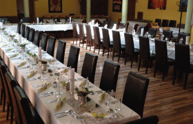 Festively decorated wedding table in a room with yellow walls and brick arches.