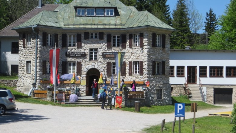 Alpine and local history museum Hohe Wand with visitors and flags in front of the entrance.