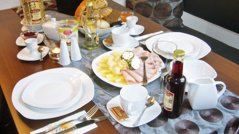 Pension Leichtfried, © Pension Leichtfried Breakfast table with crockery, cold cuts, bread, muesli and drinks.