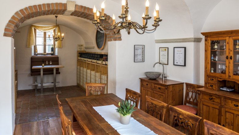 Cozy room with wooden furniture, chandelier and wine rack.