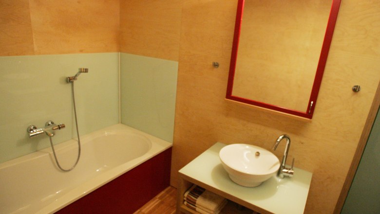 Modern bathroom with bathtub, washbasin and mirror.