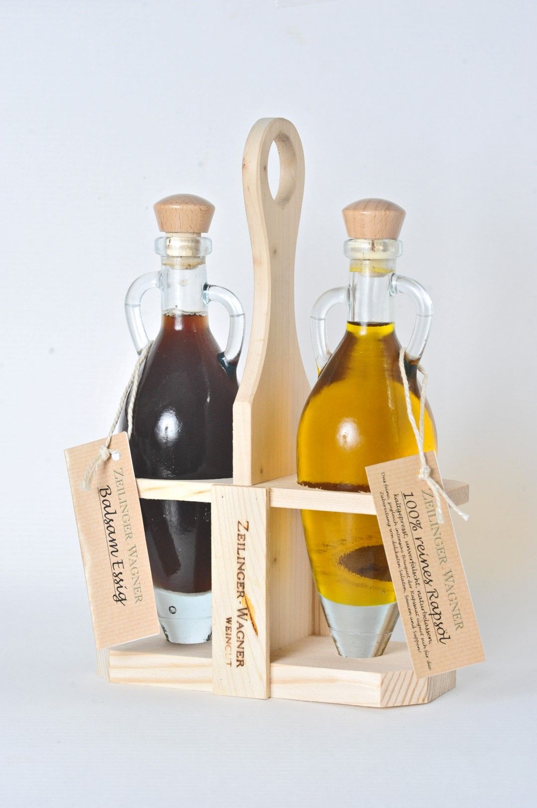 Two glass bottles with vinegar and oil in a wooden stand.