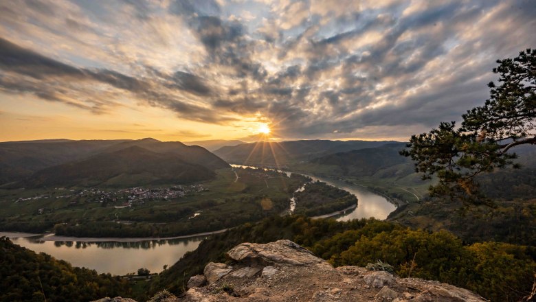 Sunset over the Danube in D&uuml;rnstein, with a view of the river and hills.