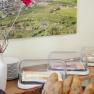 Breakfast buffet with bread rolls, cheese and sausage under covers. A landscape with vineyards in the background.