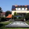 A house with solar panels and a covered pool in the garden.