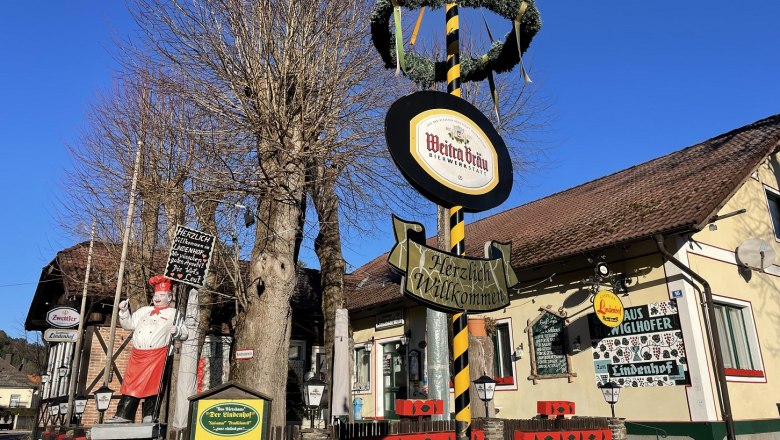 Gasthaus Lindenhof in Pernitz with maypole and signs.