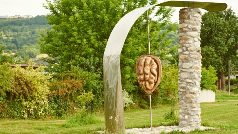 Sculpture of a walnut in Krummnu&szlig;baum, surrounded by trees and meadow.