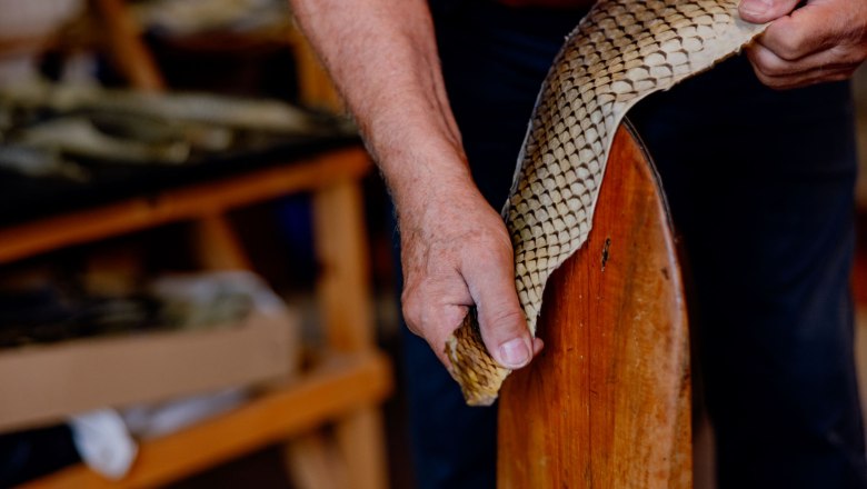 Close-up of hands working on a piece of fish leather.