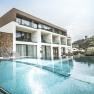 Modern boutique hotel with pool and sun loungers, surrounded by green countryside.