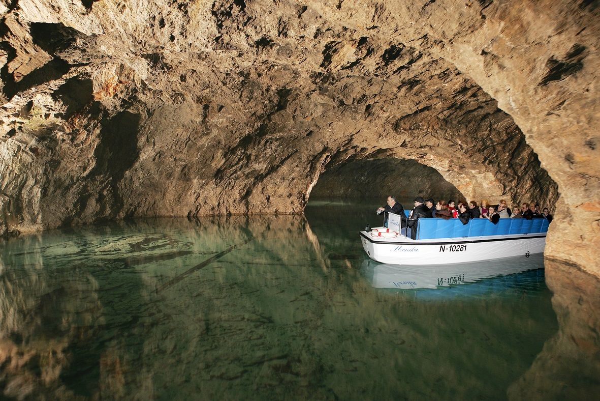 Boat tour in an underground cave with tourists on a small boat.