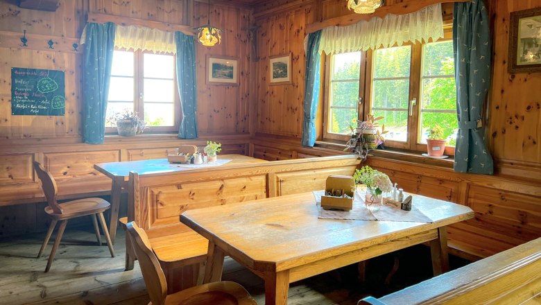 Cozy parlor with wooden furniture, blue curtains and plants on the tables.