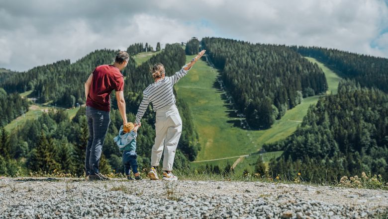 Family looking at a wooded mountain on the Semmering.